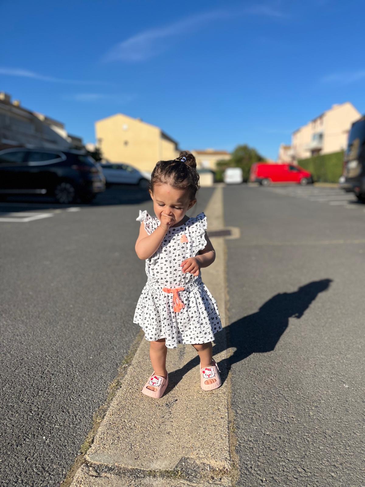 Une petite fille dans la rue, sur le chemin du retour